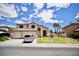 Charming two-story home with a large front yard, three car garage, and a sunny blue sky at 5412 Rainbows End Dr, Las Vegas, NV 89149