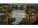 Stately home with a flat roof, surrounded by trees, showcasing a sparkling pool and city views at night at 56 Quail Run Rd, Henderson, NV 89014