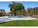 Pool area with lounge chairs, lush lawn, tall trees, and manicured hedges at 56 Quail Run Rd, Henderson, NV 89014