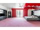 Spacious bedroom with a king bed, pink carpet, and large windows with red curtains at 56 Quail Run Rd, Henderson, NV 89014
