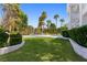 Sprawling backyard featuring a pool, lush lawn, tall trees, and a two-story home at 56 Quail Run Rd, Henderson, NV 89014