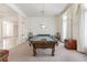 Spacious game room with billiard table, columns, carpet flooring, and decorative window coverings at 56 Quail Run Rd, Henderson, NV 89014