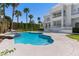 Backyard featuring a sparkling pool, well-manicured lawn, and an elegant two-story home at 56 Quail Run Rd, Henderson, NV 89014