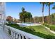 Backyard with a pristine pool, lush lawn, mature palm trees, and manicured hedges for privacy at 56 Quail Run Rd, Henderson, NV 89014