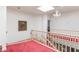 Upstairs hallway with wood railing and abundant natural light from skylights at 56 Quail Run Rd, Henderson, NV 89014