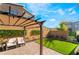Outdoor living space features a covered seating area and artificial turf, perfect for relaxation and entertainment at 6141 May River St, Las Vegas, NV 89148