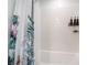 The tub and shower include a tropical shower curtain and tiled walls at 6141 May River St, Las Vegas, NV 89148