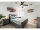 A comfy bedroom is complete with a ceiling fan, wood-look flooring, and natural light to create a serene escape at 6141 May River St, Las Vegas, NV 89148