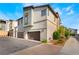 View of the home's side and rear showcasing a two-car garage with a long driveway and manicured landscaping at 6141 May River St, Las Vegas, NV 89148