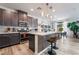 Well-lit kitchen boasts stainless steel appliances, a kitchen island with bar stools, and modern dark brown cabinetry at 6141 May River St, Las Vegas, NV 89148
