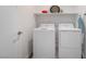 The laundry room includes a washer, a dryer and overhead shelving for efficient organization and convenience at 6141 May River St, Las Vegas, NV 89148
