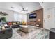 Stylish living room featuring a modern sectional sofa, sleek coffee table, and a decorative wood-paneled accent wall at 6141 May River St, Las Vegas, NV 89148
