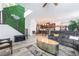 View of the living room flowing into kitchen, with modern staircase, and sleek furnishings against a feature wall at 6141 May River St, Las Vegas, NV 89148