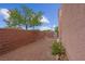 Backyard area featuring gravel and partial brick wall with a tree at 6599 Netherseal Ave, Las Vegas, NV 89139