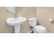 Simple bathroom featuring a white pedestal sink and toilet at 6599 Netherseal Ave, Las Vegas, NV 89139