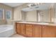 Bathroom with a double sink vanity, large mirror, and separate tub area at 6599 Netherseal Ave, Las Vegas, NV 89139