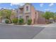 Two-story tan home featuring an attached garage, and landscaped front yard at 6599 Netherseal Ave, Las Vegas, NV 89139