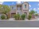 Two-story tan home featuring an attached garage, balcony and landscaped front yard at 6599 Netherseal Ave, Las Vegas, NV 89139