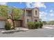 Two-story tan home featuring an attached garage, balcony and manicured front yard at 6599 Netherseal Ave, Las Vegas, NV 89139