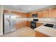 An eat-in kitchen featuring wooden cabinets, modern appliances, and countertop space at 6599 Netherseal Ave, Las Vegas, NV 89139