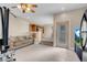 Open living room with tile floors, tan walls, ceiling fan, and natural light at 6599 Netherseal Ave, Las Vegas, NV 89139