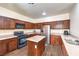 Well-lit kitchen with stainless steel appliances, wooden cabinets, and a central island, offering both style and functionality at 6623 Hurkling Stone Ave, Las Vegas, NV 89139