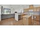 Open-concept kitchen with wood cabinets, an island, and a view into the living room at 6705 Frances Celia Ave, Las Vegas, NV 89122