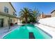 Backyard pool with a diving board, covered patio, and a towering palm tree, perfect for outdoor enjoyment at 6736 Quinella Dr, Las Vegas, NV 89103