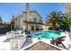 Backyard pool area with a diving board, outdoor kitchen, and shaded seating under a mature palm tree at 6736 Quinella Dr, Las Vegas, NV 89103