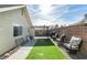 Spacious backyard with artificial grass, covered patio, seating, and a brick wall, offering a relaxing outdoor space at 709 Jonathan Glen Way, Las Vegas, NV 89145