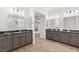 Dual vanities with gray cabinetry and granite countertops in a well-lit, modern bathroom at 7165 N Grand Canyon Dr, Las Vegas, NV 89149