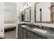 Bathroom featuring dual sinks, granite counters, and rustic wood-frame mirrors at 7165 N Grand Canyon Dr, Las Vegas, NV 89149