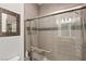 This modern bathroom features a tiled shower with glass door and a decorative mosaic mirror at 7165 N Grand Canyon Dr, Las Vegas, NV 89149