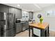 This kitchen features stainless steel appliances, gray cabinets, and wood look tile flooring at 7165 N Grand Canyon Dr, Las Vegas, NV 89149