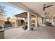 Inviting covered patio featuring an outdoor kitchen, pizza oven, fireplace, and comfortable seating area at 7165 N Grand Canyon Dr, Las Vegas, NV 89149