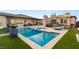 This pool features a lounging area, a sun umbrella, and a fire pit sitting area at 7165 N Grand Canyon Dr, Las Vegas, NV 89149
