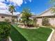 Lush backyard featuring artificial turf, mature trees, and a covered patio area at 7892 Nookfield Dr, Las Vegas, NV 89147
