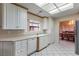 Well-lit kitchen features white cabinetry, granite countertops, and stainless appliances adjacent to the formal dining area at 8901 Litchfield Ave, Las Vegas, NV 89134