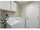 Well-equipped laundry room with washer, dryer, and storage cabinets at 8901 Litchfield Ave, Las Vegas, NV 89134