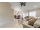 Sun-filled living room featuring tile floors, a plush sectional sofa, and an adjacent dining area with a chandelier at 8901 Litchfield Ave, Las Vegas, NV 89134