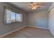 Cozy bedroom with a light blue accent wall, laminate flooring, and a window with sheer curtains at 893 Fairway Dr, Boulder City, NV 89005
