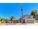 Charming two-story home with a well-manicured yard and mature palm trees under a bright blue sky at 893 Fairway Dr, Boulder City, NV 89005