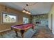 Spacious game room featuring a pool table, stone accent wall with fireplace, and sliding glass doors to the outside at 893 Fairway Dr, Boulder City, NV 89005