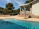 Stunning pool area with ample seating, mature trees, and a lush green golf course at 893 Fairway Dr, Boulder City, NV 89005