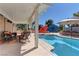 Luxurious pool area with seating, umbrellas, and well-manicured landscaping at 893 Fairway Dr, Boulder City, NV 89005