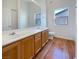 Bathroom featuring double sinks, wood-look floors, and a large mirror at 8985 S Durango Dr # 2081, Las Vegas, NV 89113