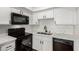 Updated kitchen with black appliances, white cabinets, and marble countertops at 905 Sulphur Springs Ln # 101, Las Vegas, NV 89128