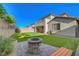 Backyard with artificial turf, fire pit, and bench for outdoor entertaining at 10142 Skye Saddle Ave, Las Vegas, NV 89166