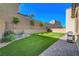 Manicured backyard featuring artificial grass, bench, string lights, and barbecue at 10142 Skye Saddle Ave, Las Vegas, NV 89166