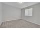 Empty bedroom with neutral carpet, walls, and a window providing natural light at 10142 Skye Saddle Ave, Las Vegas, NV 89166